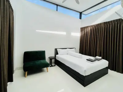a bedroom with a bed and a green chair at 3bdr Pool Villa Laguna Park-2 in Ban Phru Champa