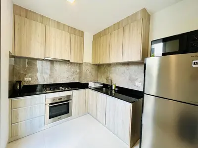 a kitchen with wooden cabinets and a stainless steel refrigerator at 3bdr Pool Villa Laguna Park-2 in Ban Phru Champa
