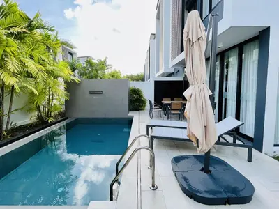 a patio with a pool and an umbrella at 3bdr Pool Villa Laguna Park-2 in Ban Phru Champa