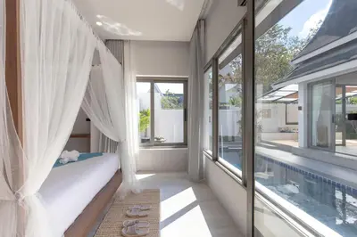 a bedroom with a bed and a swimming pool at 3 Bedrooms Private Pool Villa near Laguna in Laguna Phuket