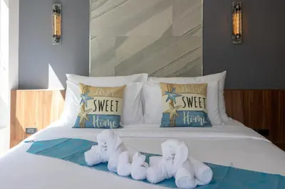 a bed with white sheets and pillows with the disney sword theatre at 3 Bedrooms Private Pool Villa near Laguna in Laguna Phuket