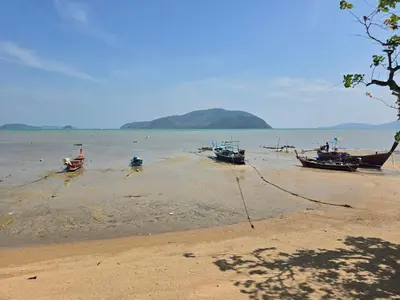 three boats sitting on the shore of a beach at The beach front Condo in Ban Saiyuan (1)