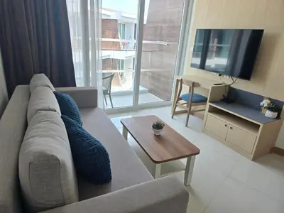 a living room with a couch and a tv at The beach front Condo in Ban Saiyuan (1)