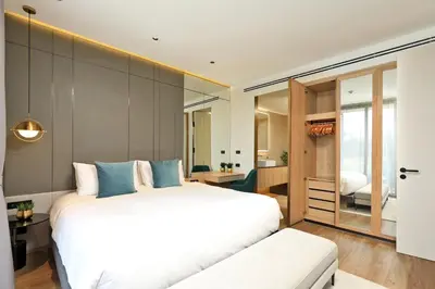 a bedroom with a large white bed and a bathroom at 2bdr Apartment with Bath near Bangtao Beach C512 in Laguna Phuket