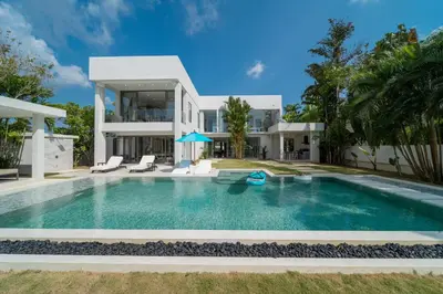 a villa with a swimming pool in front of a house at Lumière Villas Phuket - Golfside Retreat in Laguna in Laguna Phuket