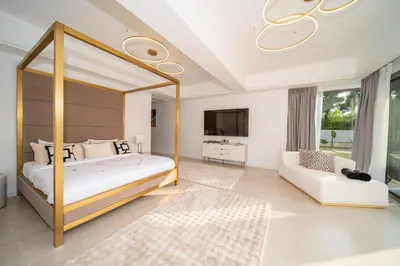 a bedroom with a canopy bed and a couch at Lumière Villas Phuket - Golfside Retreat in Laguna in Laguna Phuket
