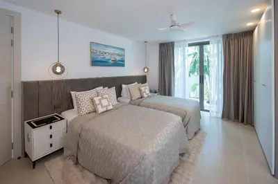a hotel room with two beds and a window at Lumière Villas Phuket - Golfside Retreat in Laguna in Laguna Phuket