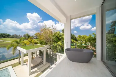 a bathroom with a tub and a view of the ocean at Lumière Villas Phuket - Golfside Retreat in Laguna in Laguna Phuket