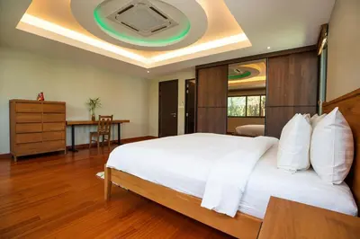 a bedroom with a large white bed with a ceiling at Luxury 5 Bedroom Staffed Botanica Villas in Ban Phru Champa