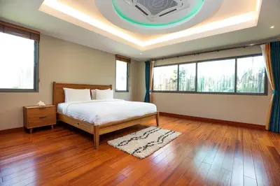a bedroom with a bed and a ceiling with windows at Luxury 5 Bedroom Staffed Botanica Villas in Ban Phru Champa