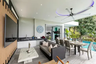a kitchen and dining room with a couch and a table at Seaview three bedroom villa in Bangtao area in Ban Thalat Choeng Thale