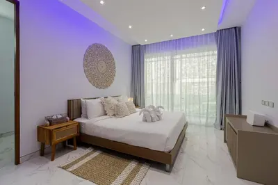 a bedroom with a bed and a large window at Seaview three bedroom villa in Bangtao area in Ban Thalat Choeng Thale