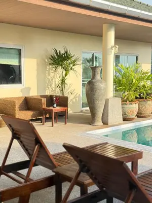 a patio with a couch and chairs and a vase at Over the Moon villa in Patong Beach