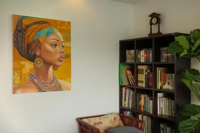 a book shelf with a painting of a woman at Over the Moon villa in Patong Beach