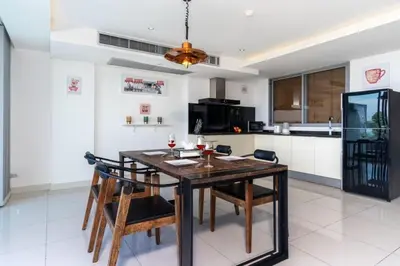a kitchen with a wooden table and some chairs at The View Phuket F9 in Kata Beach
