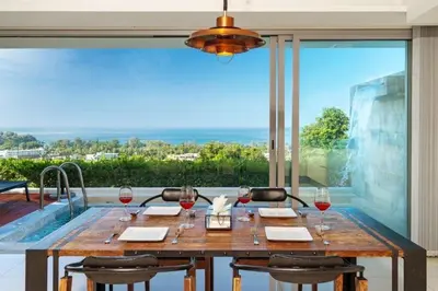 a table with wine glasses and a view of the ocean at The View Phuket F9 in Kata Beach