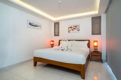 a bedroom with a large white bed with two lamps at The View Phuket F9 in Kata Beach