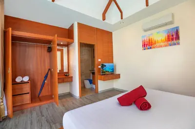 a bedroom with a white bed with a red towel on it at Tropical 2BR Pool Villa 3D12 in Gated Residence Rawai VIP Villas in Rawai Beach