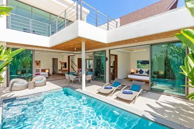 an indoor swimming pool in a house with glass walls at Modern Thai-Balinese 2-Storey Pool Villa Kael in Ka Villas Residence, 500m from Famous Rawai Beach Seafood Market in Rawai Beach