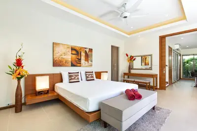 a bedroom with a large bed and a living room at Modern Thai-Balinese 2-Storey Pool Villa Kael in Ka Villas Residence, 500m from Famous Rawai Beach Seafood Market in Rawai Beach