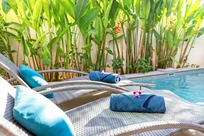 a group of chairs with blue cushions on them next to a pool at Modern Thai-Balinese 2-Storey Pool Villa Kael in Ka Villas Residence, 500m from Famous Rawai Beach Seafood Market in Rawai Beach