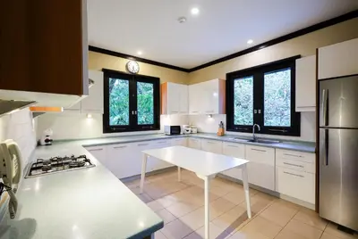 a kitchen with white cabinets and a white table at Katamanda villa Eden Large Villa near Kata Beach in Kata Beach