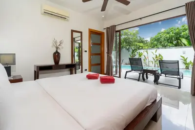 a bedroom with a large bed and a balcony at Pool Villa Martin 3BR, Rawai in Rawai Beach