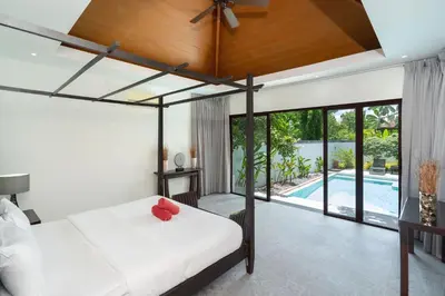 a bedroom with a bed with a red flower on it at Pool Villa Martin 3BR, Rawai in Rawai Beach