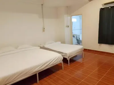 two beds sitting in a room with a mirror at XX GO INN Phuket Patong Beach in Patong Beach