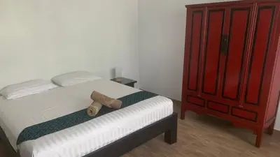 a bed with a pair of shoes sitting on it at Villa Loma & Patong 6 chambres in Patong Beach