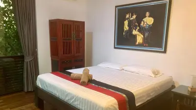 a bedroom with a bed with a teddy bear on it at Villa Loma & Patong 6 chambres in Patong Beach