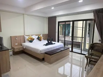 a bedroom with a bed and a balcony at Sumaka Hotel Karon in Kata Beach