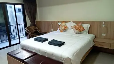 a bedroom with a large white bed with two pillows on it at Sumaka Hotel Karon in Kata Beach