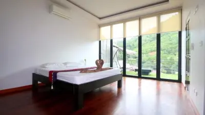a bedroom with a bed and a large window at Villa Loma & Patong 7 chambres in Patong Beach