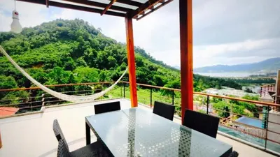 a table and chairs on a balcony with a view at Villa Loma & Patong 7 chambres in Patong Beach