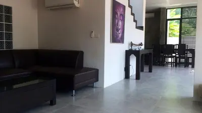 a living room with a couch and a table at Villa Loma & Patong 7 chambres in Patong Beach