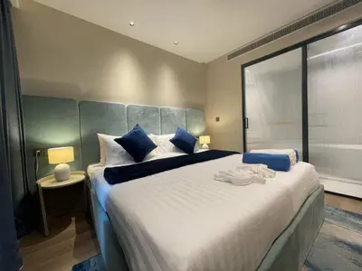 a bedroom with a large white bed with blue pillows at Laya Residence Memoory Layan in Ban Na Bon