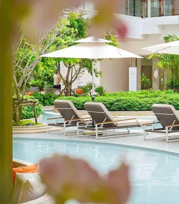 a group of chairs and umbrellas next to a swimming pool at Laya Residence Memoory Layan in Ban Na Bon