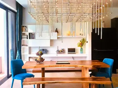 a dining room with a wooden table and blue chairs at 20 - Tranquil Retreat near Marriott Naiyang Beach in Nai Yang Beach