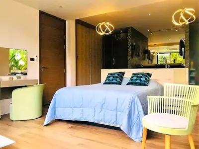 a bedroom with a bed with blue sheets and two chairs at 20 - Tranquil Retreat near Marriott Naiyang Beach in Nai Yang Beach