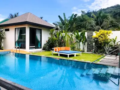 a villa with a swimming pool in front of a house at 20 - Tranquil Retreat near Marriott Naiyang Beach in Nai Yang Beach