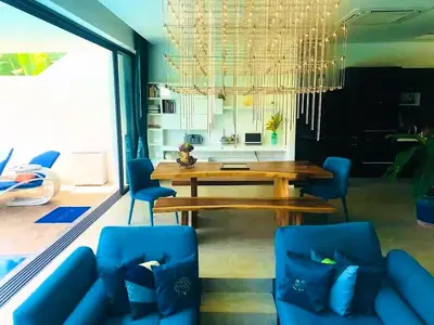 a dining room with a wooden table and blue chairs at 20 - Tranquil Retreat near Marriott Naiyang Beach in Nai Yang Beach