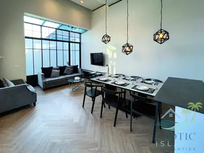 a living room with a table and a couch at Stylish 3BR Private Pool Villa Bangtao Beach in Ban Pak Lak