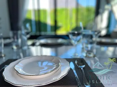 a table with a plate and a fork and knife at Stylish 3BR Private Pool Villa Bangtao Beach in Ban Pak Lak