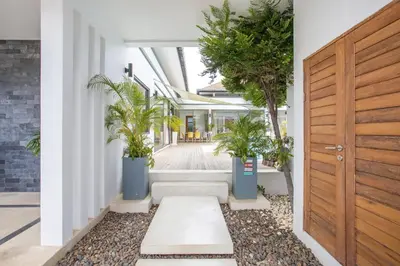 a hallway with potted plants and a wooden door at Luxury 4BR Villa Virginie, Salt Pool, Rawai in Rawai Beach