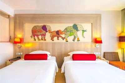a hotel room with two beds and a painting of elephants at Ramada by Wyndham Phuket Deevana in Patong Beach