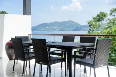 a black table and chairs with a view of the water at Atika Villa 7 ocean view pool villa in Patong Beach