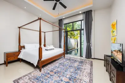 a bedroom with a canopy bed and a television at Villa Neya 2BR Private Pool Close to Naiharn Beach in Rawai Beach