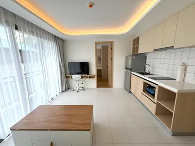a kitchen with a table and a tv in a room at New 2br apartment -stylish Fantasea Kamala Condo in Kamala Beach