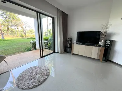 a living room with a flat screen tv and a chair at Private apartment at Allamanda II by Lofty in Bang Tao Beach